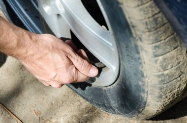insan elleri arabanın tekerleğine hava pompalamak için araba pompası hortumu takın