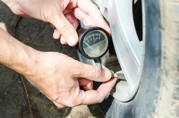 Fechar pneu de inflar mecânico e verificar a pressão do ar com calibre — Fotografia de Stock