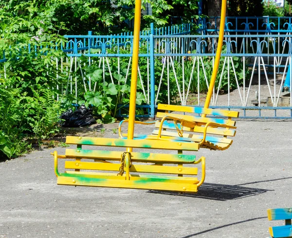 Régi fa ülések egy körhinta közelében — Stock Fotó