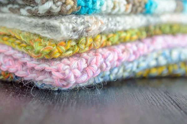 Beautiful crocheted flowers on the scarf. Many different scarves in a pile. — Stock Photo, Image
