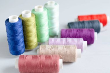 Dikiş ipliklerinin çok renkli makaraları yakın çekim. Zanaat ve hobi konsepti.