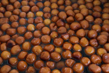 Bir sürü kakule aromalı kakule batırılmış Hindistan usulü Gulab Jamunu.