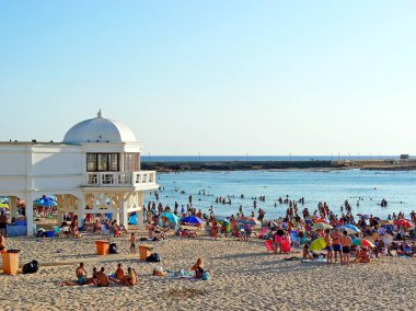 Cadiz Körfezinde La Caleta plajında gün batımı güneşlenirken insanlar. Endülüs. İspanya. Avrupa