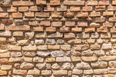 Yatay fotoğraf dokulu. Doku tuğla duvar gösterir. Duvar eski ve yıpranmış. Duvar yaz yolculuk sırasında İtalya Toskana bölgesindeki San Gimignano'da yakalanır.