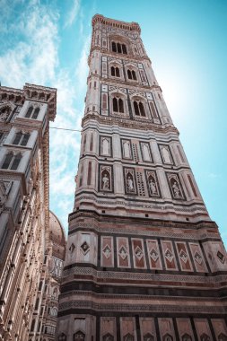 Dikey fotoğraf ünlü kulesi Campanile di Giotto ile. Kule birçok heykel ve çan üst ile renklidir. Şehirde İtalya Toskana'daki Floransa kule var. Gökyüzü beyaz bulutlar mavidir.