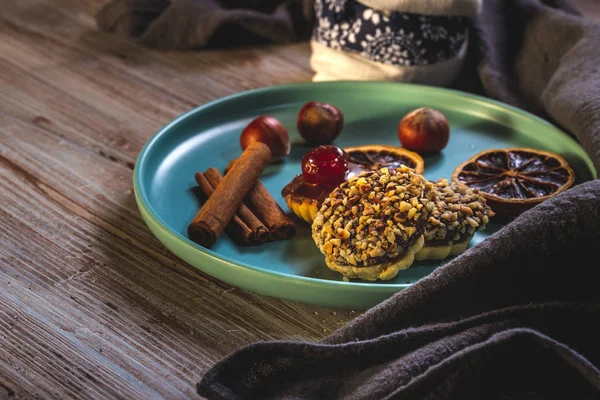 Paar stukjes gebakken zoetigheden met moer stukken en chocolade op blauw bord — Stockfoto