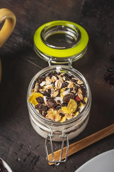 Glas vol witte yoghurt en muesli op donkere houten bord — Stockfoto