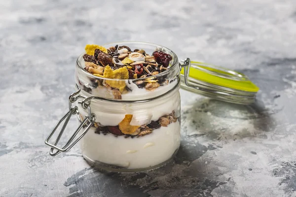 Glas vol witte yoghurt en muesli op lichte houten bord — Stockfoto
