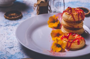 Beyaz plaka üzerinde çilek tepesi ile birkaç puf böreği çörek