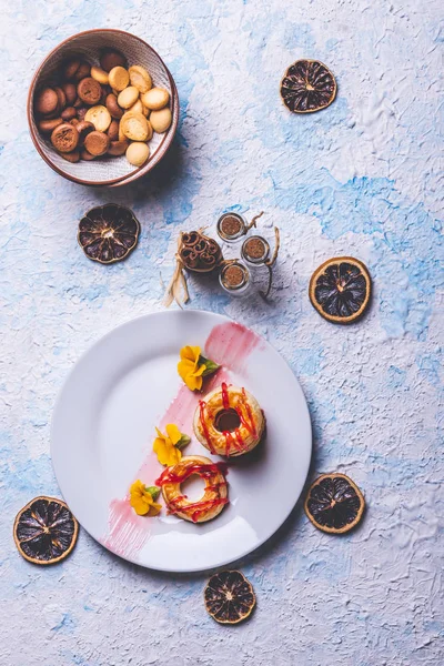 Pocas rosquillas de hojaldre con cobertura de fresa en plato blanco —  Fotos de Stock