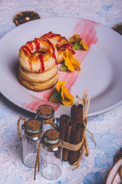 Pocas rosquillas de hojaldre con cobertura de fresa en plato blanco —  Fotos de Stock