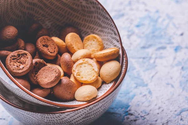 Verschillende spons koekjes in kom op lichte houten bord — Stockfoto