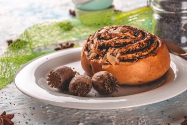 Birkaç poppyheads ile beyaz plaka üzerinde haşhaş ile tatlı haddelenmiş topuz