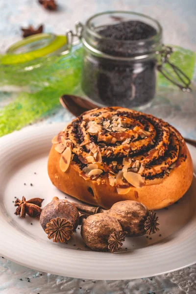 Poche teste di papavero su piatto bianco con dolce panino al forno e spezie — Foto Stock