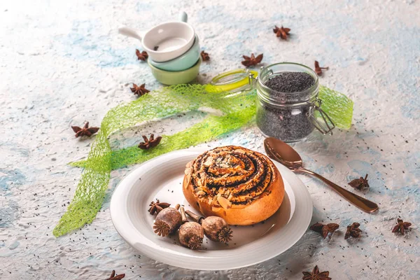 Weinig Poppy hoofden op witte plaat met zoete gebakken broodje en specerijen — Stockfoto