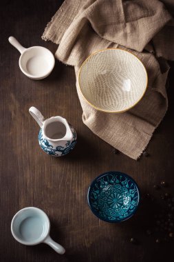 Kumaş ile koyu ahşap tahta üzerine yerleştirilen seramik kase seti