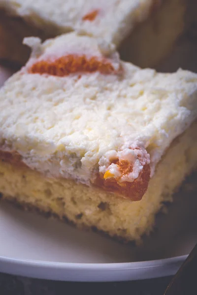 Few pieces of cake with cream topping with pieces of tangerines