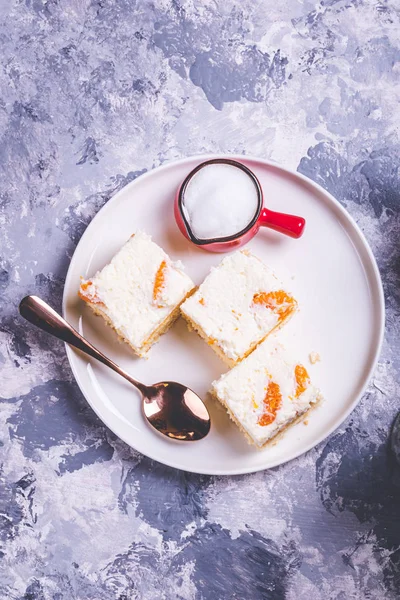 Few pieces of cake with cream topping with pieces of tangerines — Stock Photo, Image