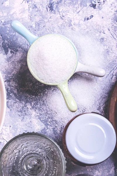 Few small caps stacked on grey board full of sugar — Stock Photo, Image