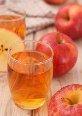 Ahşap masada içme cam elma suyu