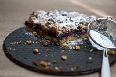 Tahta masanın üstünde öneri olan kek.