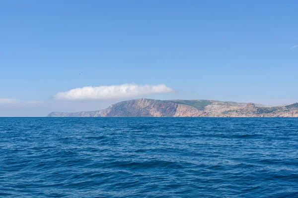 the endless expanses of the black sea, rich blue, on a bright sunny day with clouds in the sky, from the side of a pleasure boat in the black sea.