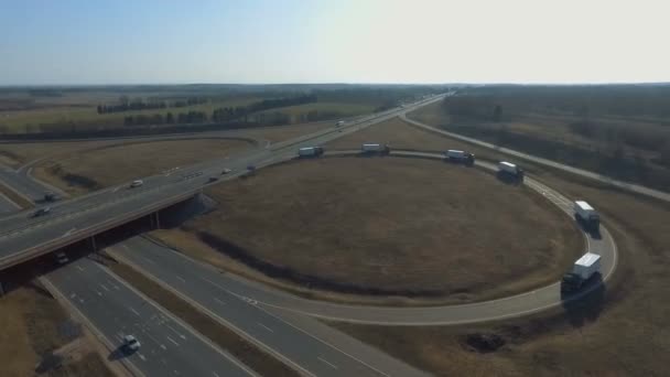 Eine große LKW-Kolonne bewegt sich um den Ring und gleitet unter der Brücke hindurch — Stockvideo