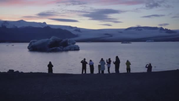 REYKJAVIK, ICELAND, PAŹDZIERNIK 10,2019 Największa laguna lodowcowa na Islandii, sylwetki ludzi przed nią — Wideo stockowe