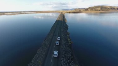 Ufkun çok ötesine giden bir yolun hava manzarası. Gölün her iki tarafında da yol var.