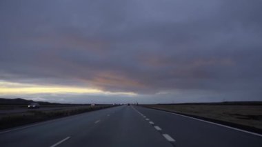 Yolun üzerinde gün batımı. Bulutlarda kırmızı gölgeler