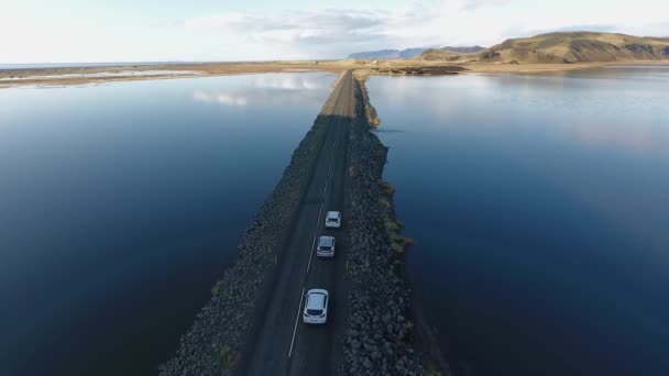 Air view of a road that goes far beyond the horizon. The road on both sides of which a lake is — Stock Video