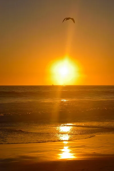 Puesta de sol naranja sobre las olas en la playa de Santa Mónica, California, EE.UU. — Foto de Stock