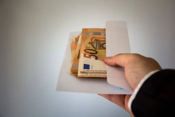 एक हाथ पैसे से भरा लिफाफा दे रहा है, 50 यूरो नोट्स — स्टॉक फ़ोटो, इमेज