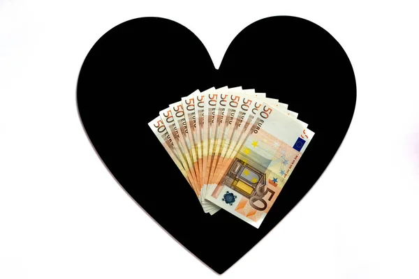 Varios billetes de 50 euros en un corazón negro. Fondo blanco. el amor es caro — Foto de Stock