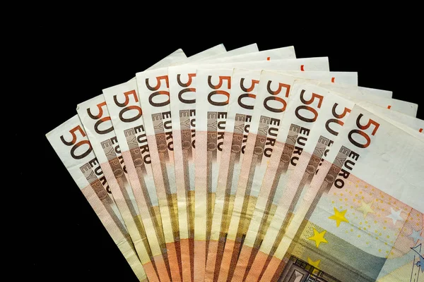 Varios billetes de 50 euros se muestran sobre un fondo negro. riqueza Imagen De Stock