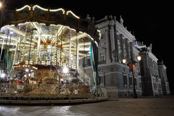 Carrusel de Navidad clásico con la fachada del palacio real como fondo, Madrid, España — Foto de Stock