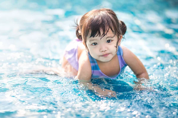 Klein meisje zwemmen in het buitenzwembad en hebben een plezier Stockfoto