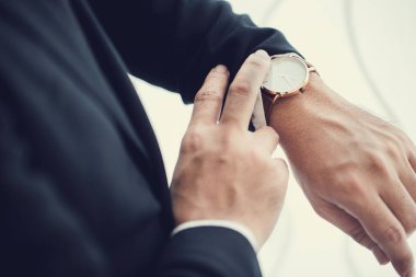 İş adamı ofisinde saatine bakıyor.
