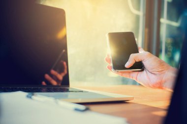 iş adamı kullanarak dizüstü bilgisayar ve cep telefonu