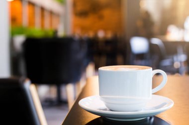 Latte Kahve ahşap masa ve Kahve dükkanı bulanıklık backg bir fincan