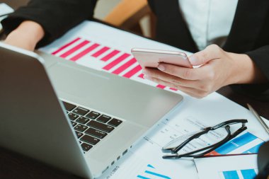 Dizüstü bilgisayar ve cep telefonu kullanan iş kadınları