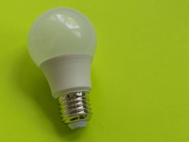 Yeşil arka planda enerji tasarruflu lamba. Elektrikli parlak ampul. Aydınlatma için cihazlar. Elektrik