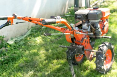 Çiftçi adam ekiciyle toprağı sürüyor. Tarım makineleri: Bahçedeki ekin ekicisi, motor ekicisi..