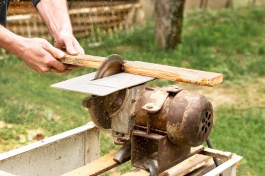 Solucan güdümlü el testeresi kullanarak tahta kesen inşaat işçisi..