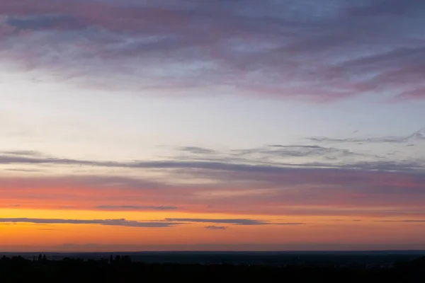 Natural Sunset Sunrise Over Field Or Meadow. Bright Dramatic Sky And Dark Ground. Countryside Landscape Under Scenic Colorful Sky At Sunset Dawn Sunrise. Sun Over Skyline, Horizon. Warm Colours.