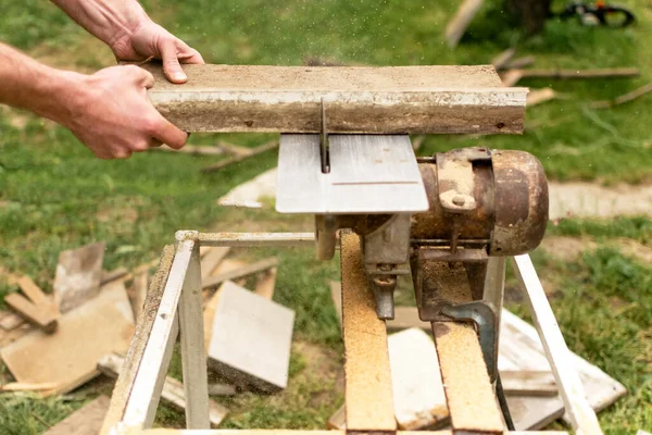 建筑承包商工人使用蜗杆驱动的手持式圆锯切割木板 — 图库照片