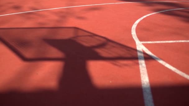 Stín na kurtu basketbalový koš s řetězy na streetbalové hřiště — Stock video