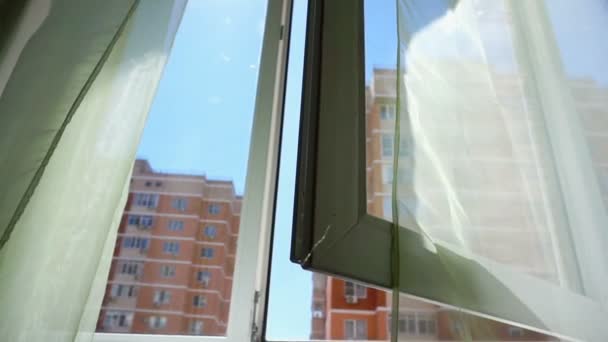 Fenster mit Vorhängen und Blick auf Himmel und Stadt. konzeptionelle Geschichte des Raumes und offener Fenster. — Stockvideo