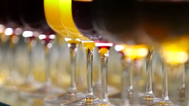 Verres avec alcool et boissons différentes, verres de vin et jus de fruits sont sur la table buffet dans un restaurant, vin rouge dans des verres . — Video