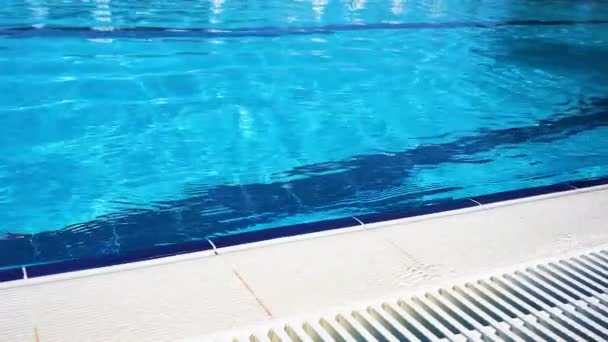 Agua superficial azul en la piscina. Borde la piscina . — Vídeo de stock